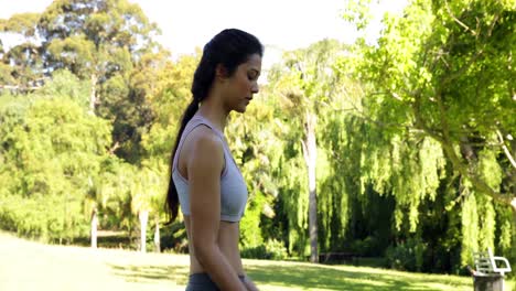 Gorgeous-fit-brunette-lifting-dumbbells-in-the-park