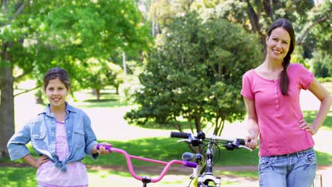 Cheerful-mother-and-daughter-on-a-bike-ride-in-the-park-together