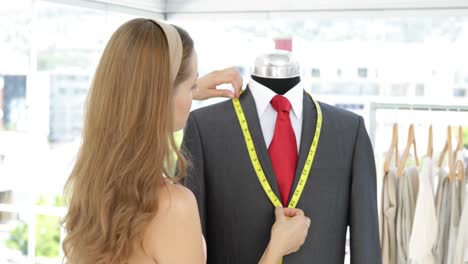 Pretty-fashion-designer-measuring-suit-lapels-on-mannequin