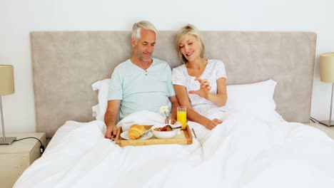 Couple-chatting-and-having-breakfast-in-bed