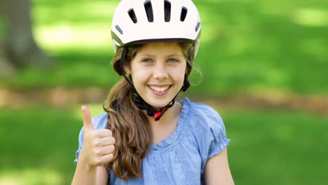 Little-girl-smiling-at-camera-on-a-pink-bike