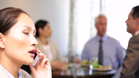 Businesswoman-talking-on-phone-at-business-lunch