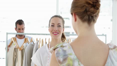 Fashion-designer-showing-a-dress-to-a-customer