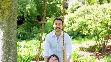 Father-pushing-his-young-son-on-a-swing