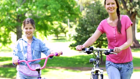 Cute-mother-and-daughter-on-a-bike-ride-together-in-the-park