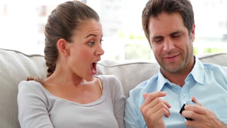 Man-surprising-his-girlfriend-with-a-present-on-the-couch