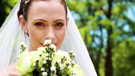 Hübsche-Braut-Lächelt-In-Die-Kamera-Und-Riecht-An-Ihrem-Blumenstrauß