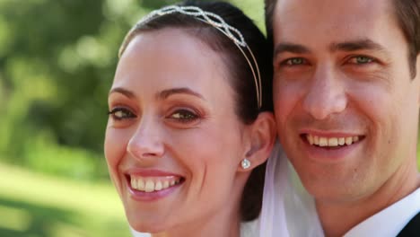 Attractive-newlyweds-smiling-at-camera