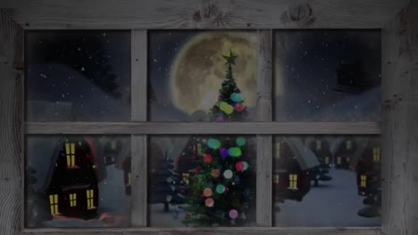 Holzfensterrahmen-Gegen-Schnee,-Der-über-Weihnachtsbaum-Und-Häuser-In-Der-Winterlandschaft-Fällt