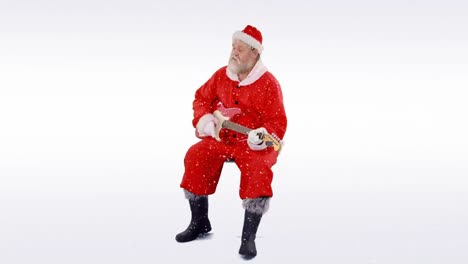 Schnee-Fällt-über-Den-Weihnachtsmann,-Der-Vor-Grauem-Hintergrund-Eine-E-Gitarre-Spielt