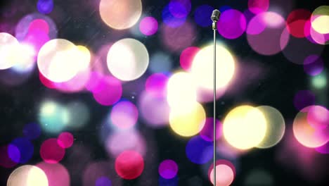Retro-metallic-microphone-against-purple-spots-of-light-against-black-background