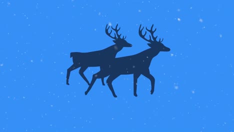 Snow-falling-over-silhouette-of-two-reindeers-walking-against-blue-background