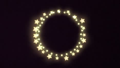 Yellow-glowing-star-shaped-decorative-fairy-lights-against-black-background