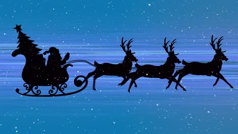 Snow-falling-over-santa-claus-in-sleigh-being-pulled-by-reindeer-and-light-trails-on-blue-background