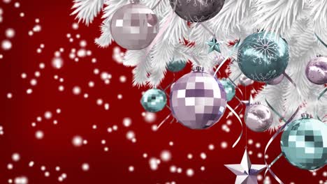 Christmas-decorations-hanging-on-christmas-tree-over-white-spots-falling-against-red-background