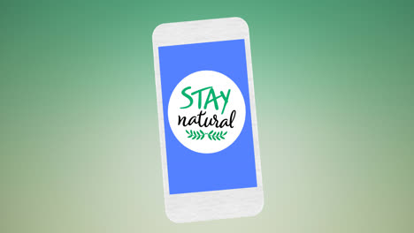 Animation-of-stay-natural-text-and-leaf-logo-on-blue-smartphone-screen,-on-green-background