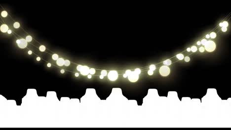 Yellow-glowing-fairy-light-decorations-hanging-against-silhouette-of-cityscape-on-black-background
