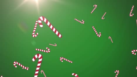 Multiple-candy-cane-icons-falling-against-spot-of-light-on-green-background