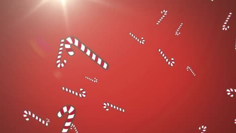 Multiple-candy-cane-icons-falling-against-spot-of-light-on-red-background