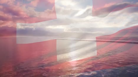 Digital-composition-of-waving-switzerland-flag-against-aerial-view-of-the-beach-and-sea-waves