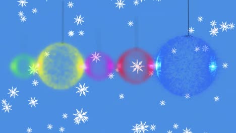 Animation-of-snow-falling-with-christmas-decorations-baubles-on-blue-background