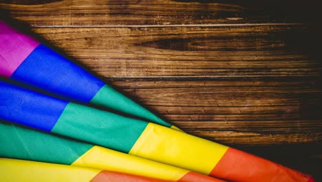 Animation-of-rainbow-flag-over-wood-table-background