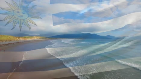 Digital-composition-of-waving-uruguay-flag-against-aerial-view-of-the-beach-and-the-sea