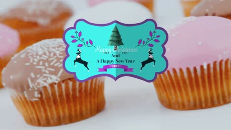 Animation-of-christmas-greetings-on-tag-over-cupcakes-on-white-background