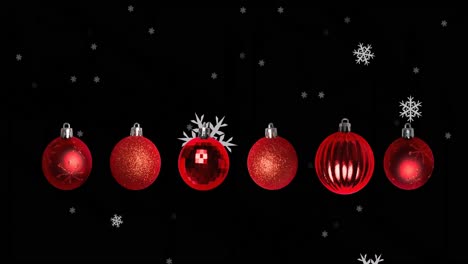 Animation-Von-Schneeflocken,-Die-über-Weihnachtskugeln-Auf-Schwarzem-Hintergrund-Fallen