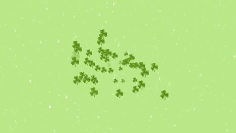 Animation-of-snow-falling-over-clover-on-green-background