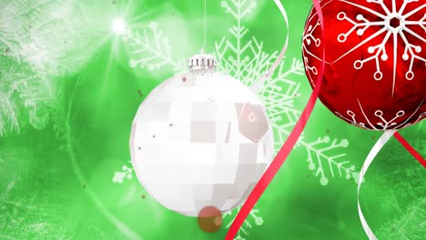 Animation-of-snow-falling-over-christmas-bauble-decorations-on-green-background
