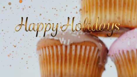 Animation-of-christmas-greetings-over-cupcakes-on-white-background
