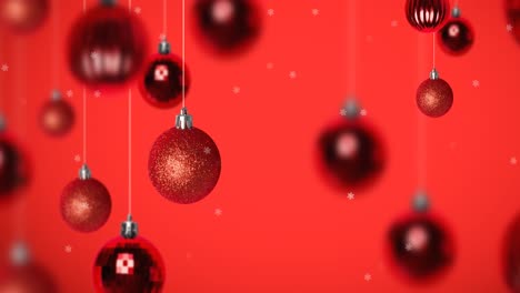 Animation-of-snow-falling-over-christmas-bauble-decorations-on-red-background