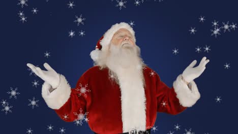 Animation-of-santa-claus-gesturing-with-snow-falling-over-blue-background