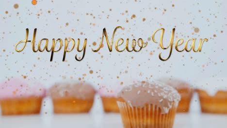 Animation-of-new-year-greetings-over-cupcakes-on-white-background