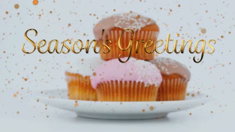 Animation-of-christmas-greetings-over-cupcakes-on-white-background