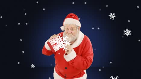 Animation-of-santa-claus-holding-present-with-snow-falling-over-blue-background