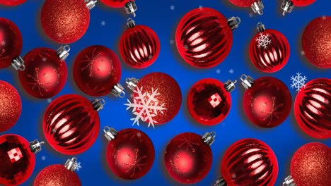 Animation-of-snow-falling-over-christmas-bauble-decorations-on-blue-background