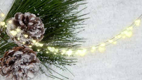 Animation-of-glowing-fairy-lights-and-christmas-pinecones-decorations
