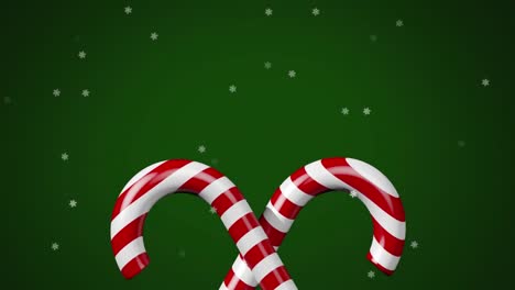 Animation-of-christmas-candies-and-snow-falling-on-green-background