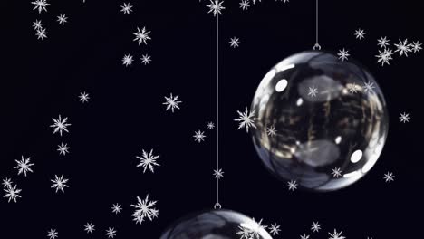 Animation-of-snow-falling-over-glass-christmas-baubles-on-black-background