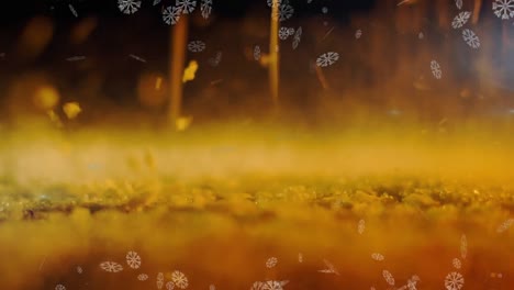 Animation-of-golden-glitter-and-snow-falling-on-yellow-background