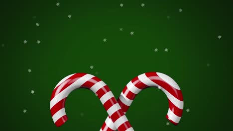 Animation-of-snow-falling-over-christmas-candies-on-green-background
