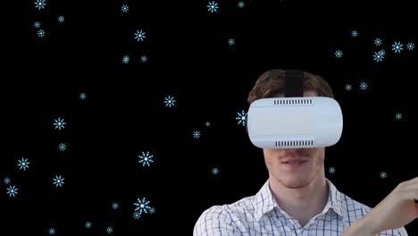 Animation-of-snow-falling-over-man-wearing-vr-glasses-on-black-background