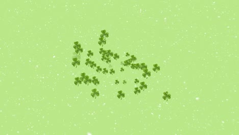 Animation-of-clover-leaves-and-snow-falling-over-green-background
