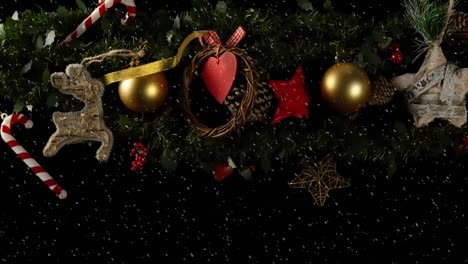 Animation-of-christmas-decorations-over-snow-on-black-background