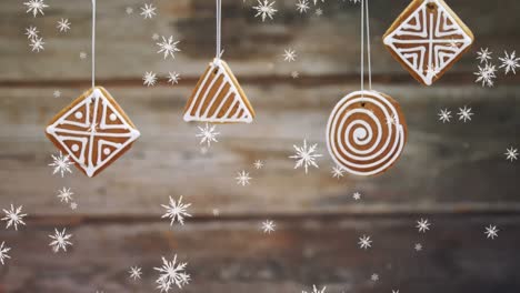 Animation-of-christmas-gingerbreds-and-snow-over-desk-boards-background