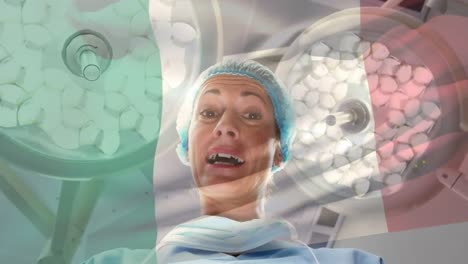 Animation-of-flag-of-italy-waving-over-female-surgeon-in-operating-theatre