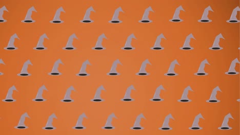 Animation-of-falling-witchs-hats-on-orange-background
