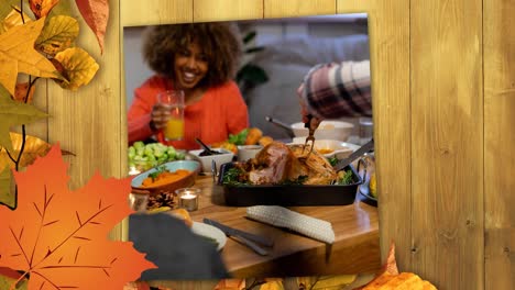 Animation-of-family-at-thanksgiving-meal-over-autumn-leaves-of-wooden-surface